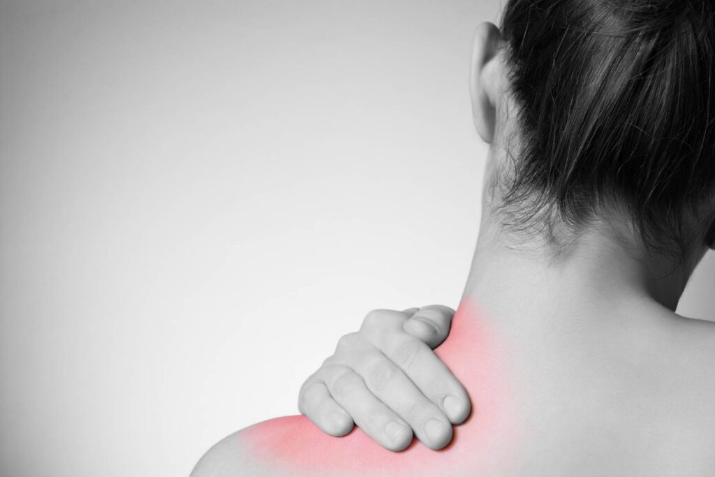 Eine Frau mit Nackenschmerzen.